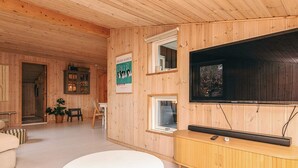 Et træinteriør med fjernsyn, et hvidt bord og et skab.