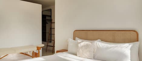 Un dormitorio con una cama, una silla y una escalera apoyada en la pared.