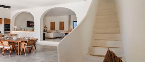 A spacious interior with a dining area, a living room, and a staircase.