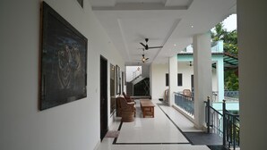 A spacious corridor with a ceiling fan, a staircase, and a view of the outside balcony. - Ranthambhore Vatika Resort (Sawai Madhopur)