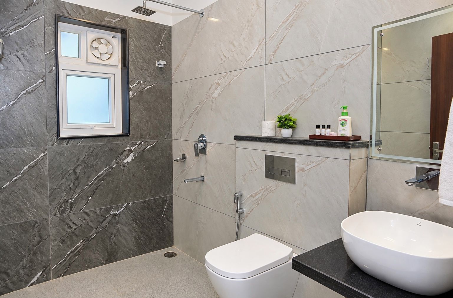 A modern bathroom with a toilet, bidet, and a large sink.