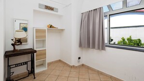 Ein Zimmer mit Fenster, einer Wandregal mit einem 'DREAM'-Schild, einer Lampe und einem kleinen Tisch mit einer Dekoration.