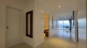 A hotel corridor with a bed, a balcony with a view, and a door. - A11 - 2 Bdr Serviced Apt, Stunning Sea View, Karon Beach (Tambon Karon)