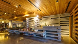 Un interior moderno con techo de madera, una estructura de bloques de hormigón y un área de descanso.