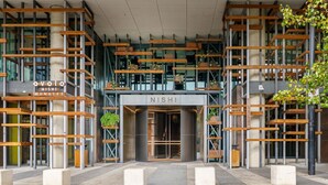 Un edificio moderno con una entrada destacada que indica "NISHI".