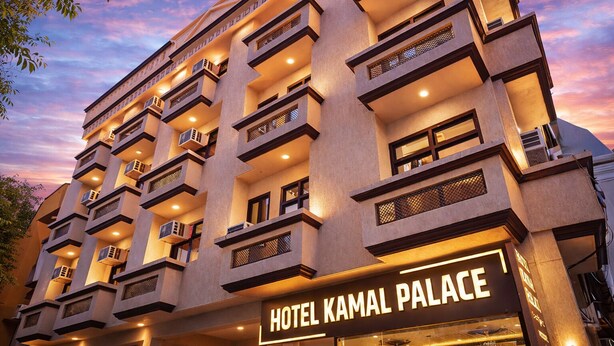 Un hotel de varios pisos con balcones y un letrero que dice "HOTEL KAMAL PALACE".