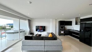 Eine moderne Wohnung mit Wohnzimmer, Küche und Balkon.