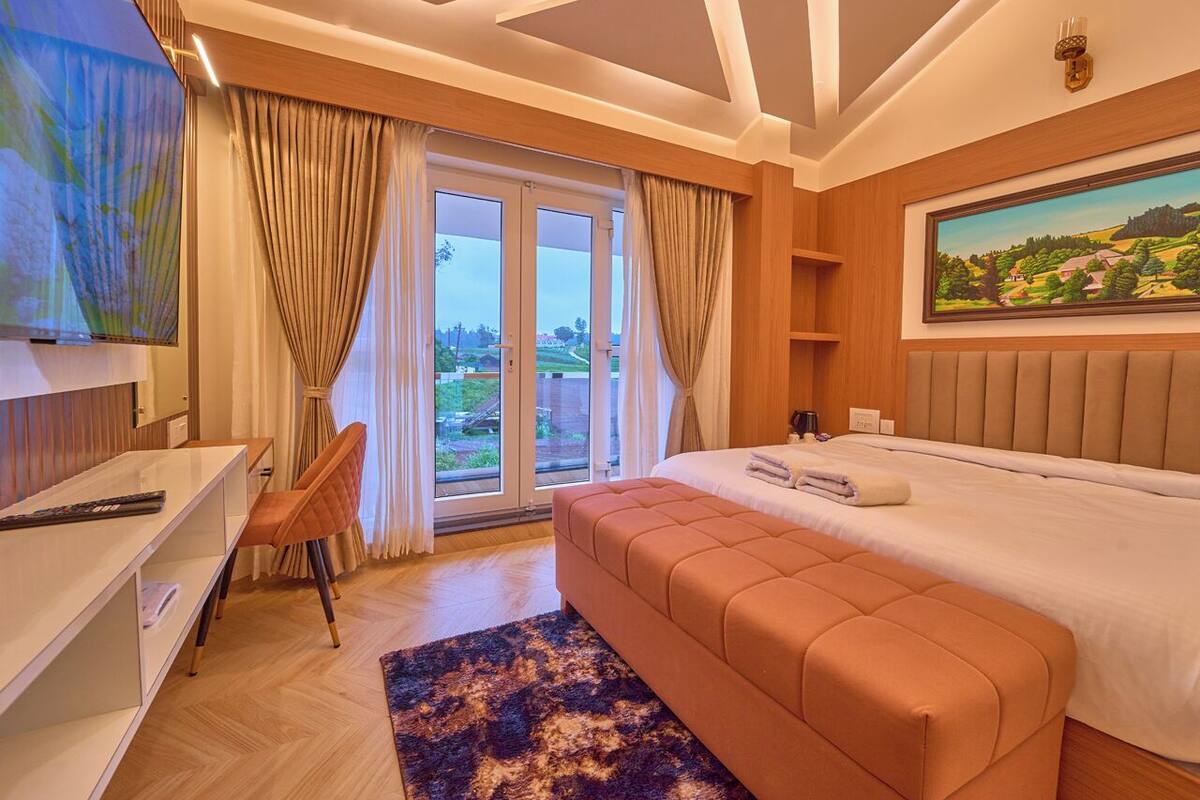 Ein Schlafzimmer mit einem großen Bett, einem Schreibtisch, einem Stuhl und einem Fernseher.