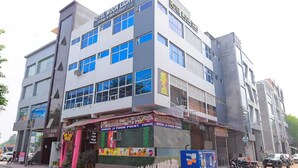 A multi-story hotel with a sign indicating it offers rooms and a restaurant. - Hotel Moon Light Kanpur (Lucknow)
