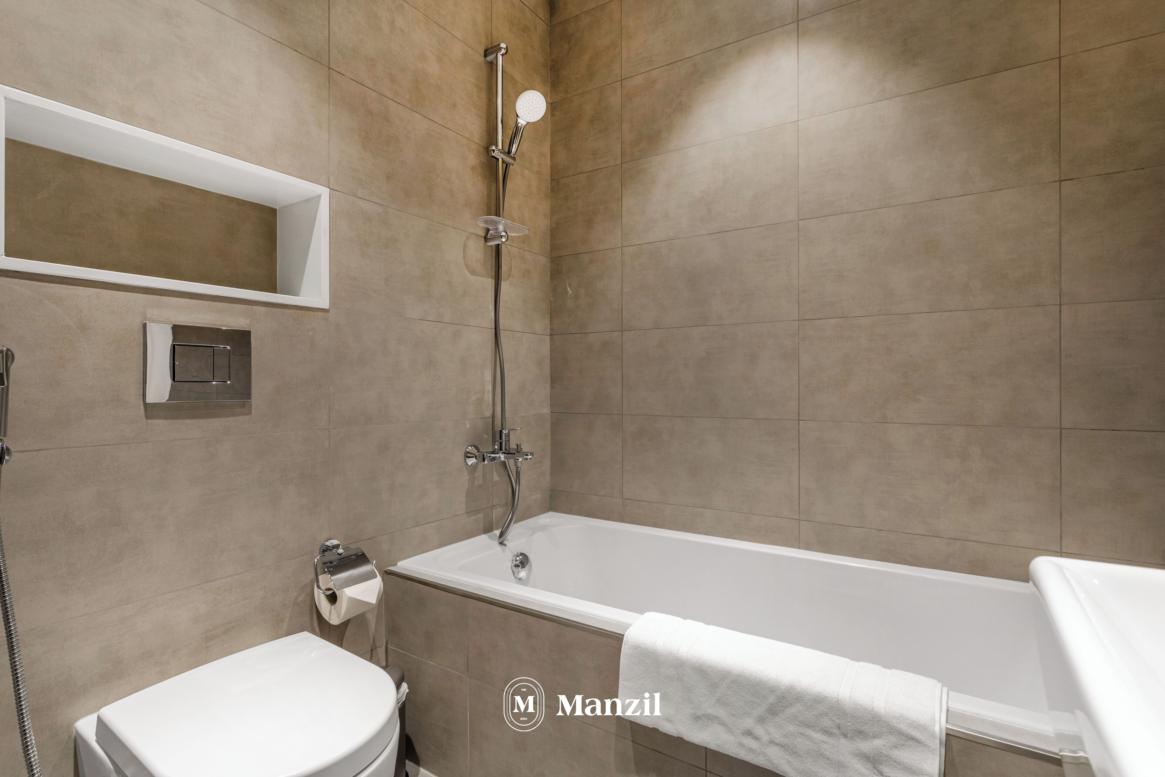 Un baño moderno con bañera, inodoro y ducha.