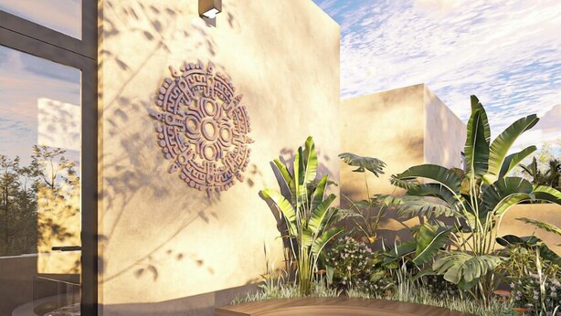 A modern outdoor relaxation area with a circular hot tub, a decorative wall, and lush greenery. - Kachava Lux (Tulum)