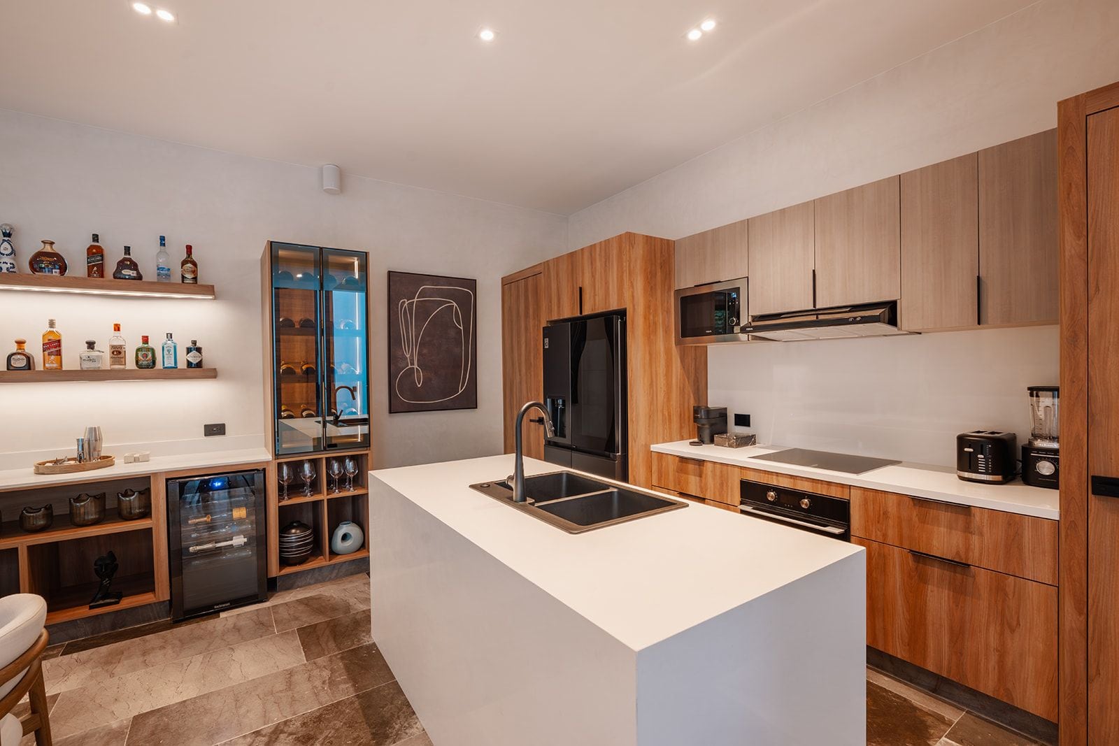 A modern kitchen with wooden cabinets, a central island, and built-in appliances.