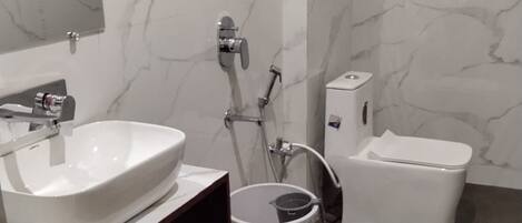 A bathroom with a white sink, a toilet, and a shower.