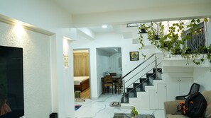 Una sala de estar moderna con una escalera, un comedor y un sofá.
