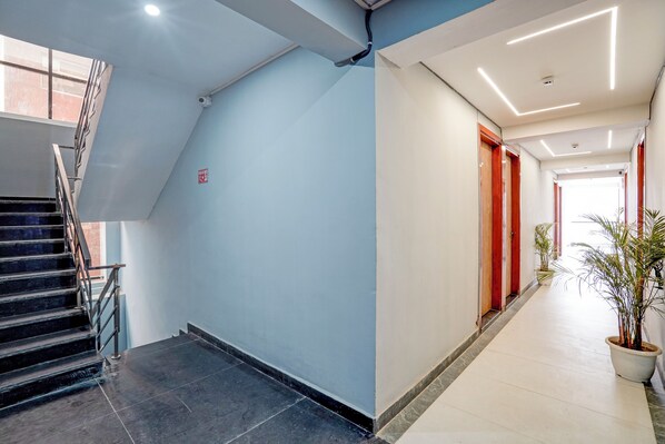 A modern interior with a staircase and a hallway. - Banquesta Suites (Noida)