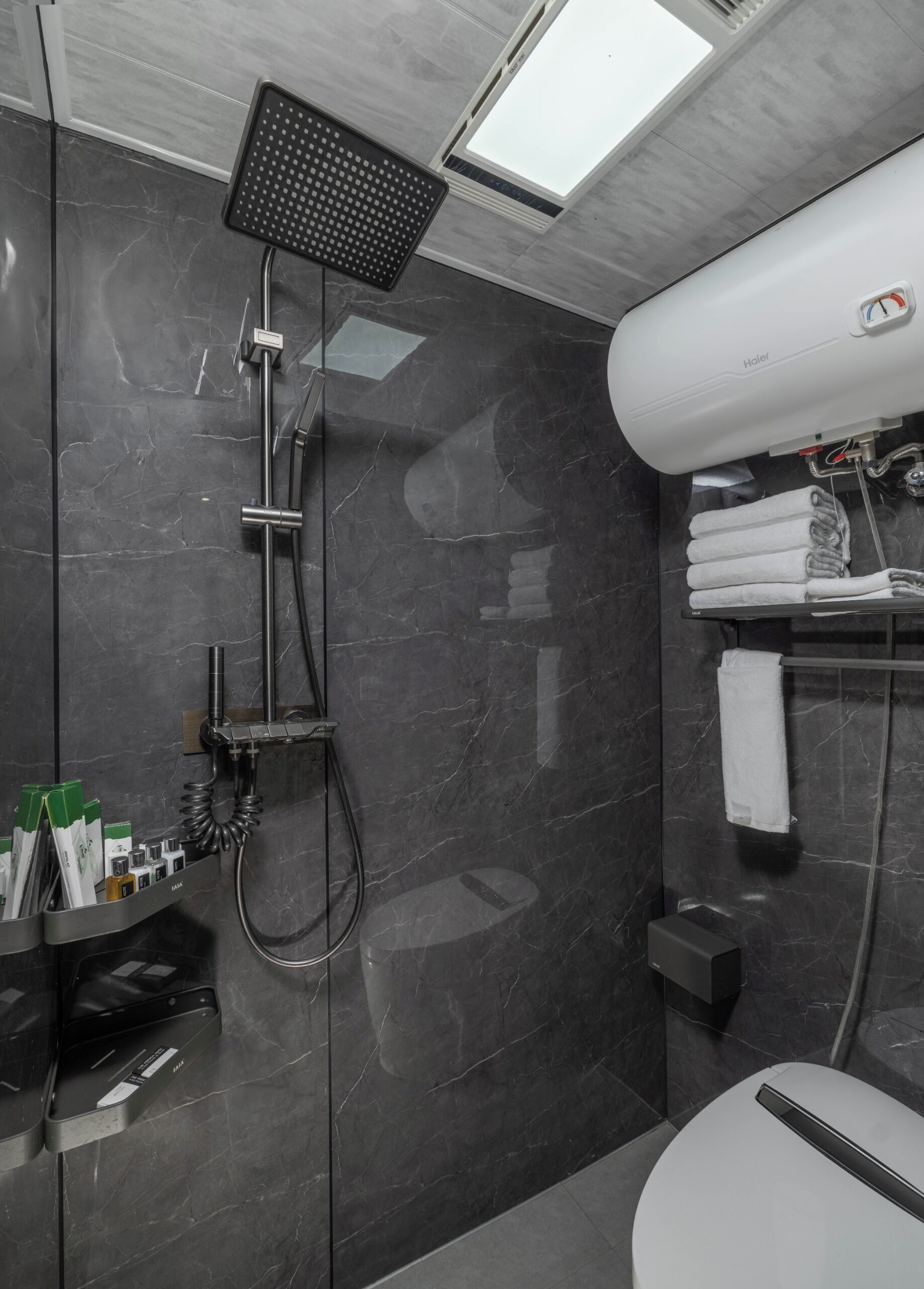 Un baño moderno con ducha, inodoro y perchero para toallas.