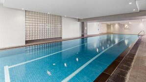 An indoor swimming pool with clear water, tiled walls, and a tiled floor. - 2-bed, 500m From The Beach With Pool, Gym & Sauna (Melbourne)