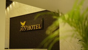 A reception desk with a sign that reads "A9 HOTEL" and a bird logo. - A79 by Khotels (Chennai)
