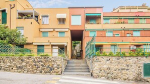 Un edificio de varios pisos con una escalera de piedra que lleva a una entrada.