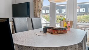 A dining area with a round table, chairs, a lamp, and books. - "Benthe" - 100m to the fjord by Interhome (Vestervig)