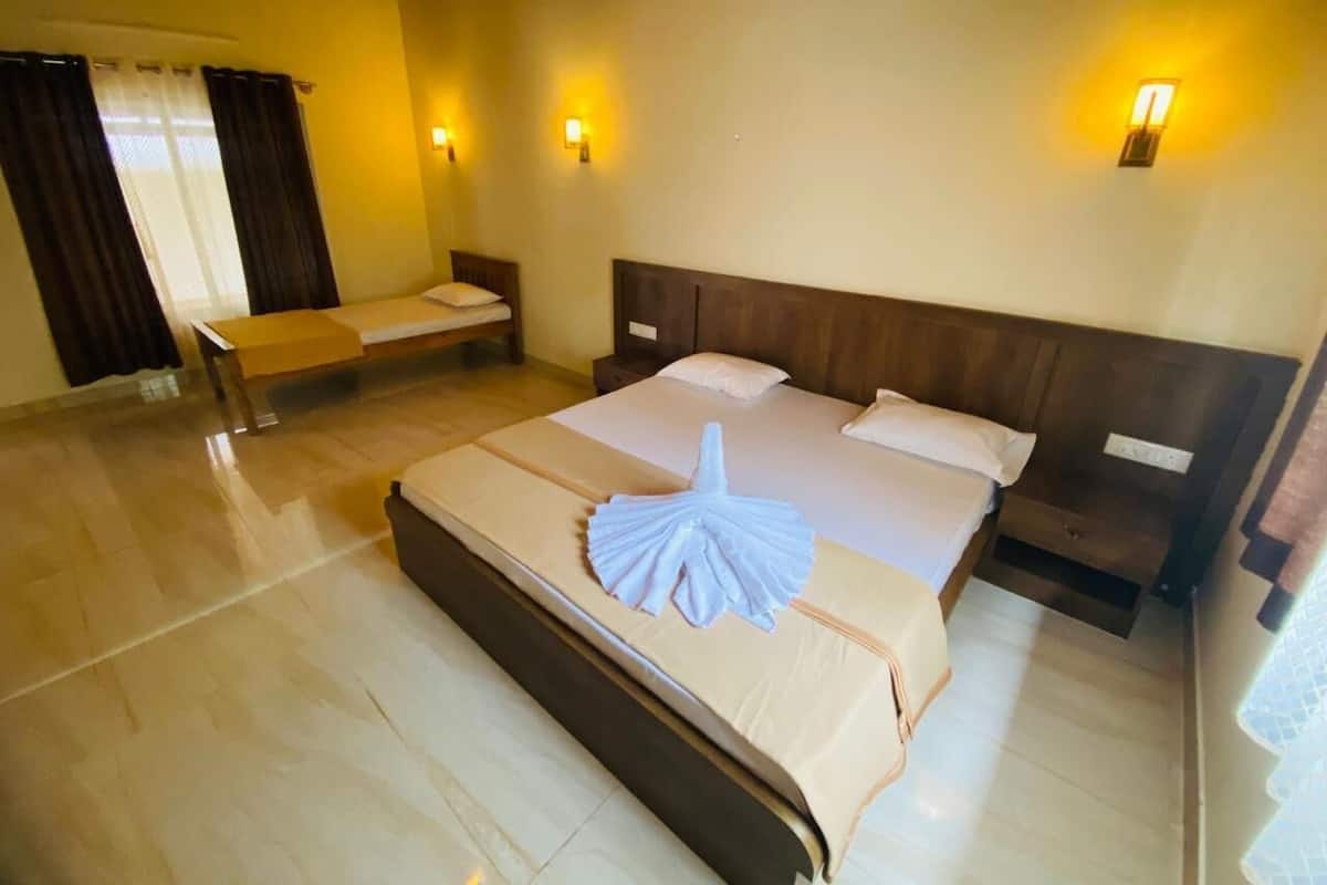 Ein Hotelzimmer mit einem großen Bett, einem Nachttisch, einem Sessel und zwei Wandleuchten.