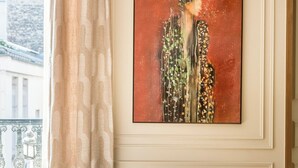 A hotel room with a bed, a window with curtains, and a framed artwork on the wall. - Merveil Signature Suite - Archives II (Paris)