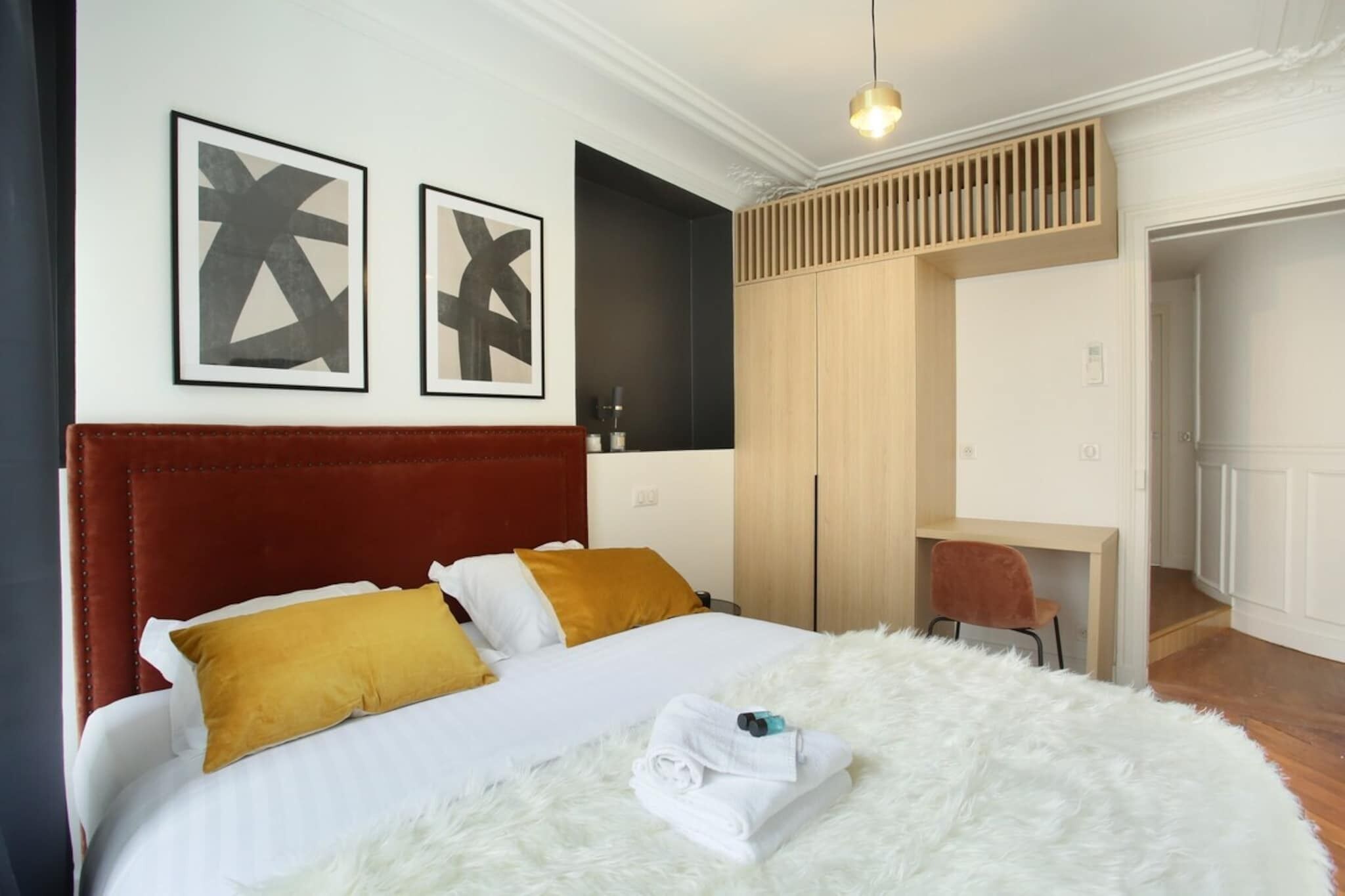 Une chambre d’hôtel avec un grand lit, un bureau et une armoire.