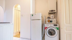 A compact kitchen with a refrigerator, microwave, and washing machine. - Comfy 2BR Apt Long Stay Matzleinsdorfer (Vienna)