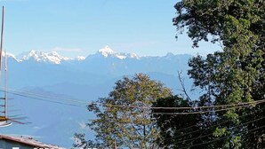 A mountain landscape with snow-capped peaks and a clear blue sky. - Paradise Homestay (Kalimpong)