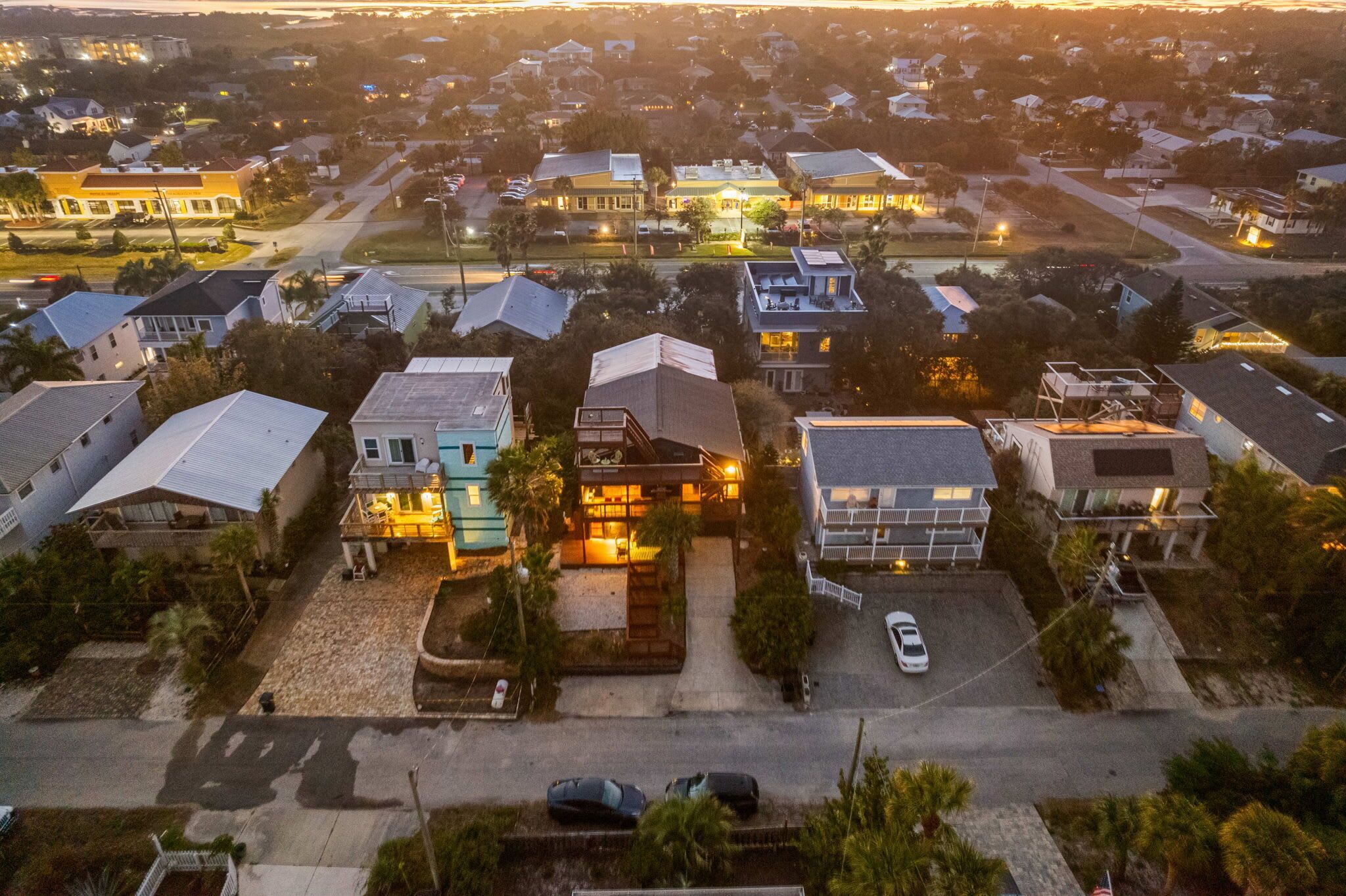 Luchtbeeld van een woonwijk met huizen, een centraal gebouw met oprit en een straat.