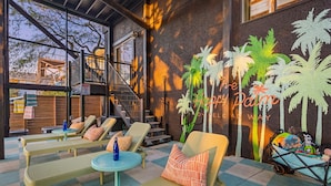A lounge area with wicker furniture, a small table with a bottle, and a stroller. - Ocean Views • Private Pool • Walk to Beach (St. Augustine)