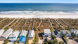 A coastal residential area with houses aligned along a beachfront, featuring a sandy beach and ocean view. - Ocean Views • Private Pool • Walk to Beach (St. Augustine)