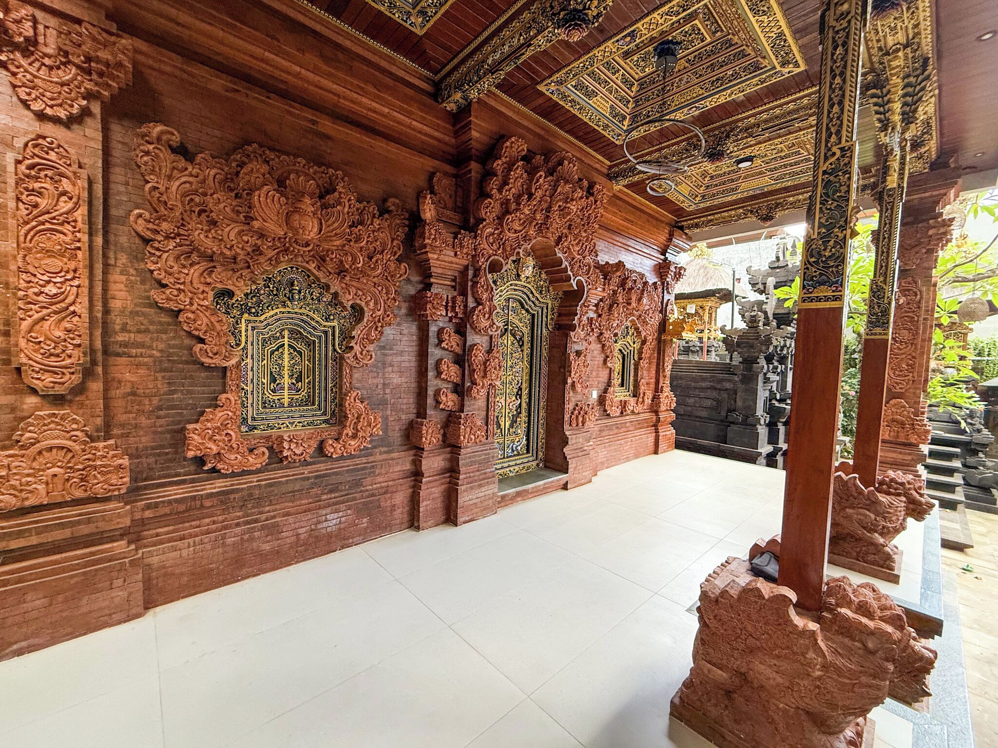 An ornate wooden structure with intricate carvings and a tiled floor.