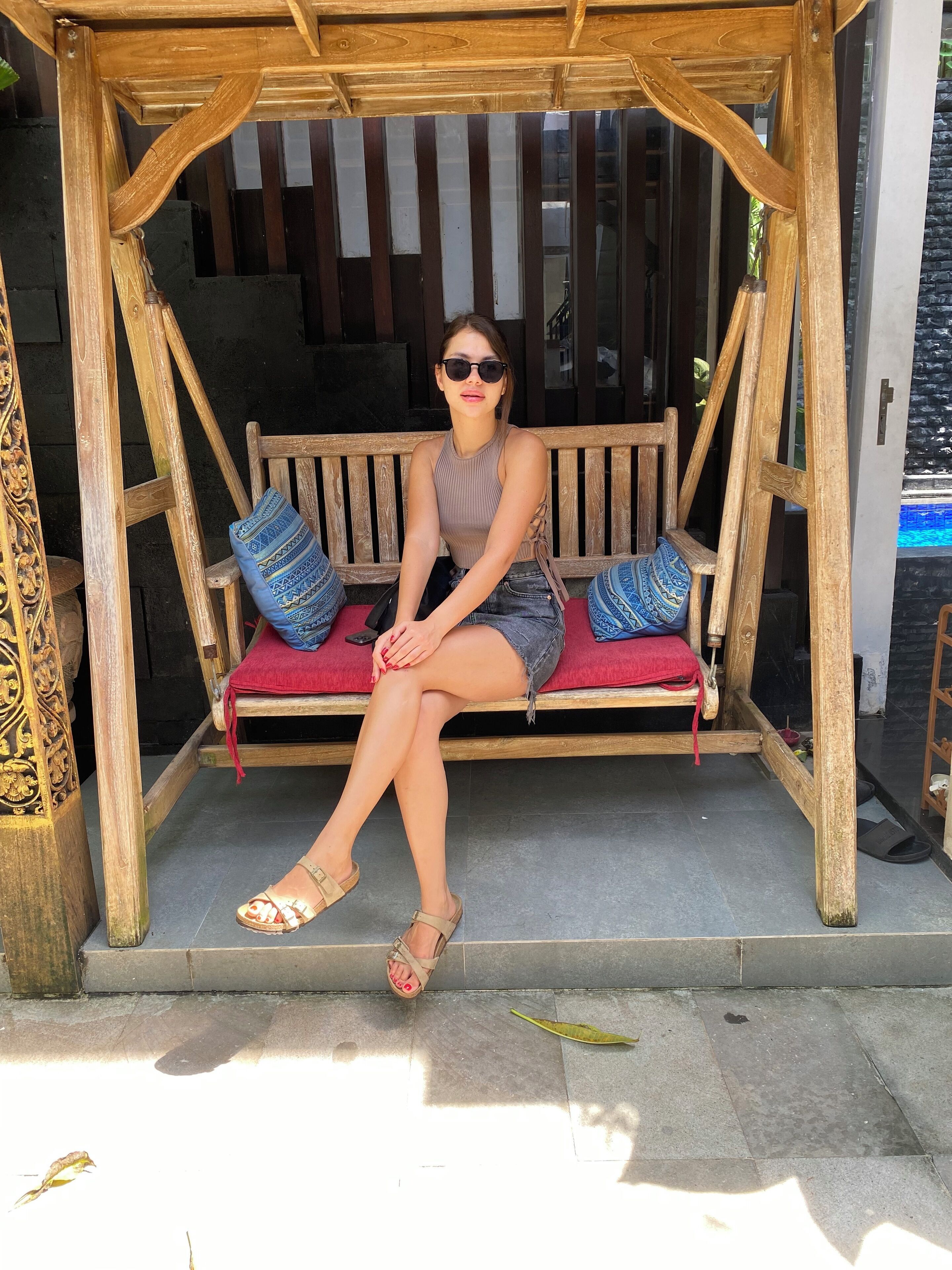 Asiento de madera con cojines, un banco y un marco de madera decorativo.