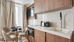 A compact kitchen with a built-in oven, a coffee maker, and a sink. - New Apartment Center of Paris Le Marais (Paris)