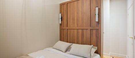 Escritorio, tabla de planchar con plancha, ropa de cama