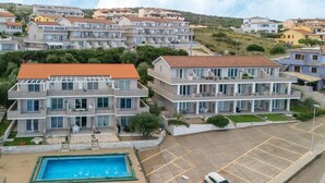 A multi-story residential building with a swimming pool and a parking area. - Apartment in with swimming pool and sea view (Castelsardo)