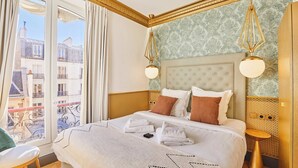 Ein Hotelzimmer mit einem großen Bett, Stadtblick und einem Balkon.