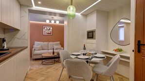 Une cuisine moderne avec un coin repas, un canapé et une table dressée pour quatre personnes.