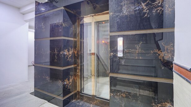 A modern elevator with glass doors and marble walls. - Hotel Greysky Residency New Delhi (New Delhi)