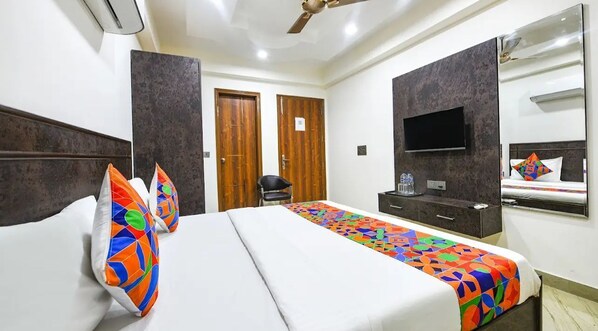 A hotel room with a bed, a TV, a wardrobe, and a mirror. - Hotel Greysky Residency New Delhi (New Delhi)