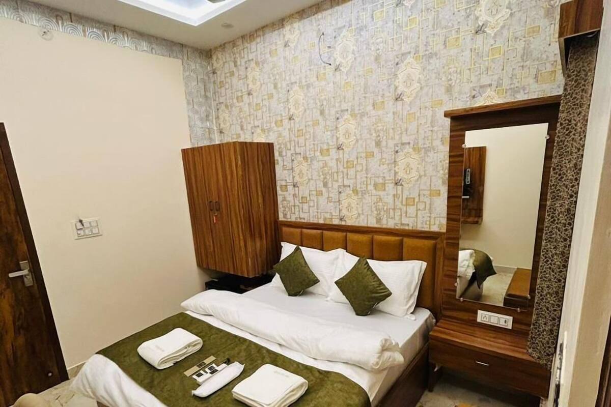 Ein Hotelzimmer mit Bett, Holzschrank, Spiegel und Deckenventilator.