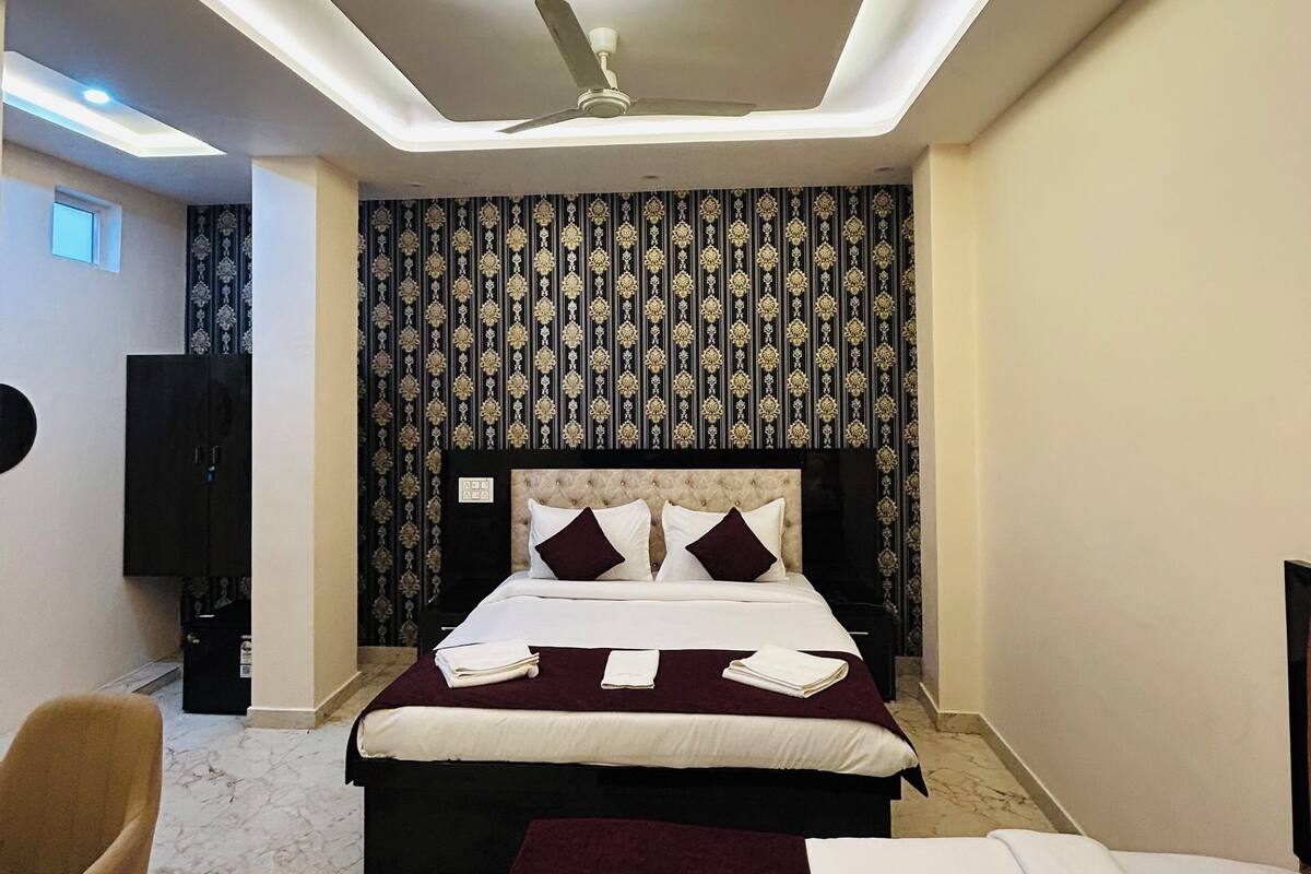 Ein modernes Hotelzimmer mit einem großen Bett, einem Deckenventilator, einem Fernseher und einem Marmorboden.