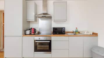 Een magnetron, een broodrooster, kookgerei, borden en bestek