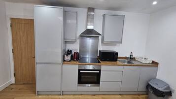 Een magnetron, een broodrooster, kookgerei, borden en bestek