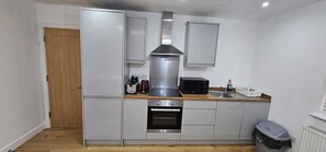 Een magnetron, een broodrooster, kookgerei, borden en bestek