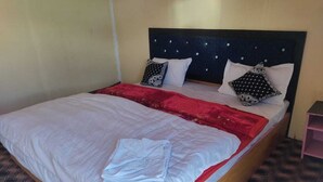 A bed with a white and red bedspread, two pillows, and a folded towel on the bed. - Pangong View Point Cottage (Leh)