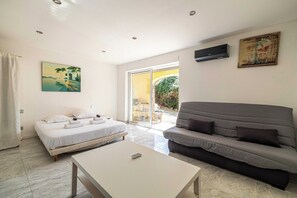 A modern room with a bed, a sofa, a coffee table, and a painting. - A/C House 4BR/10P with Pool – 40 min from Cannes (Le Tignet)
