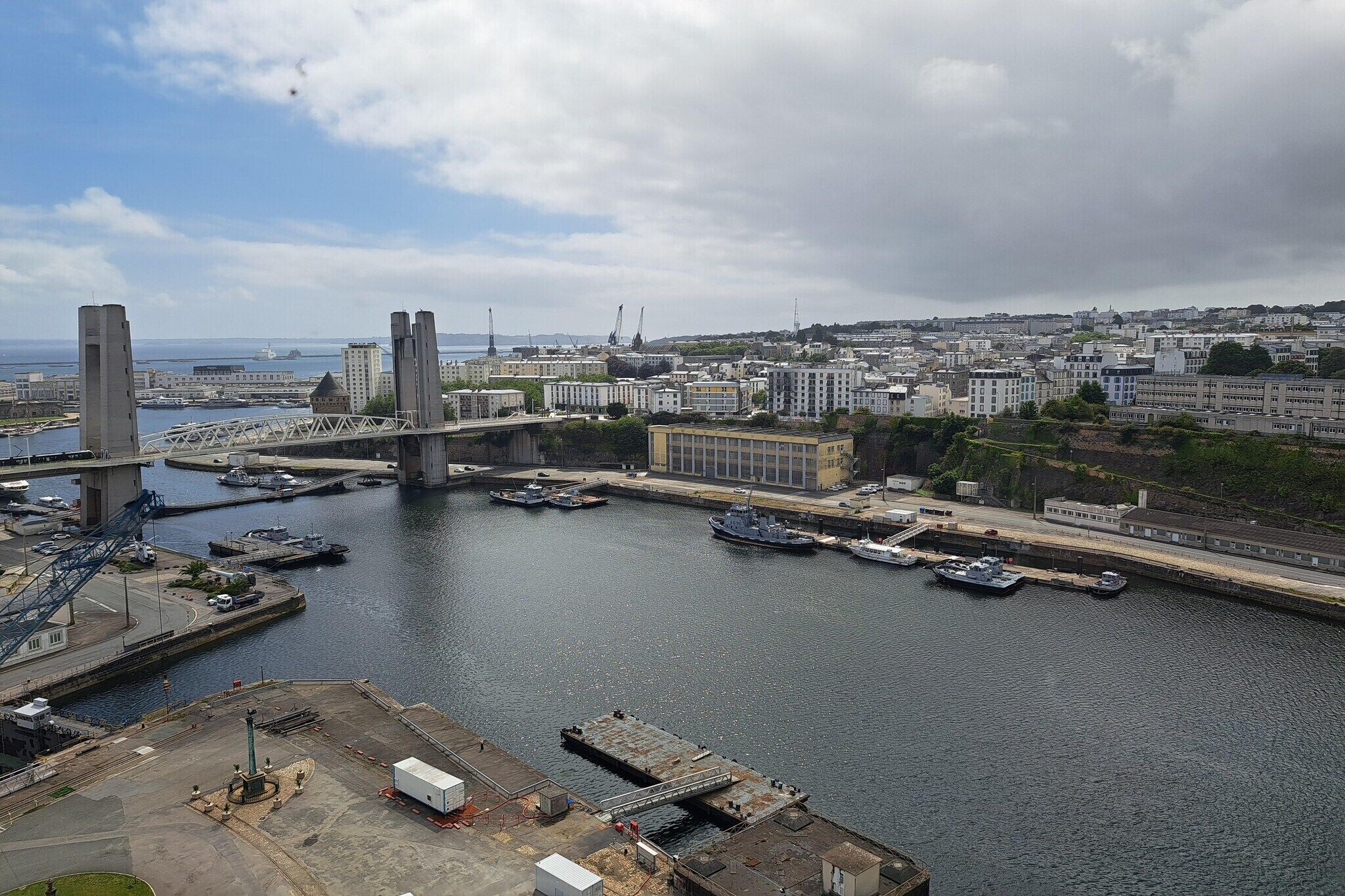 A harbor with a bridge, boats, and buildings.