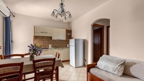 Un espace de vie compact comprenant un coin repas, une kitchenette et un canapé.